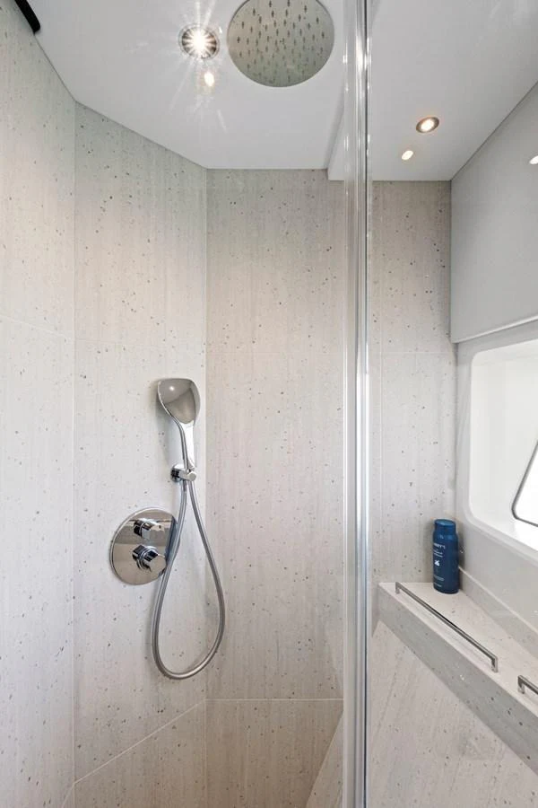 A sleek and modern yacht shower with a rainfall showerhead and minimalist design. aboard MISTY K Yacht for Sale