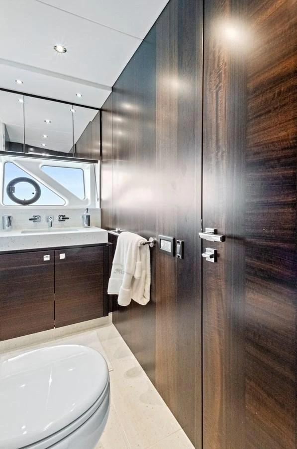 The yacht's bathroom features sleek wood paneling and modern fixtures, creating a luxurious and contemporary feel. aboard MISTY K Yacht for Sale