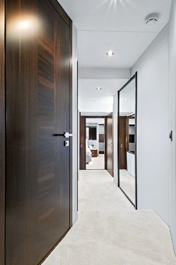 A sleek and modern hallway with wooden doors and plush carpeting leads to the yacht's interior spaces. aboard MISTY K Yacht for Sale