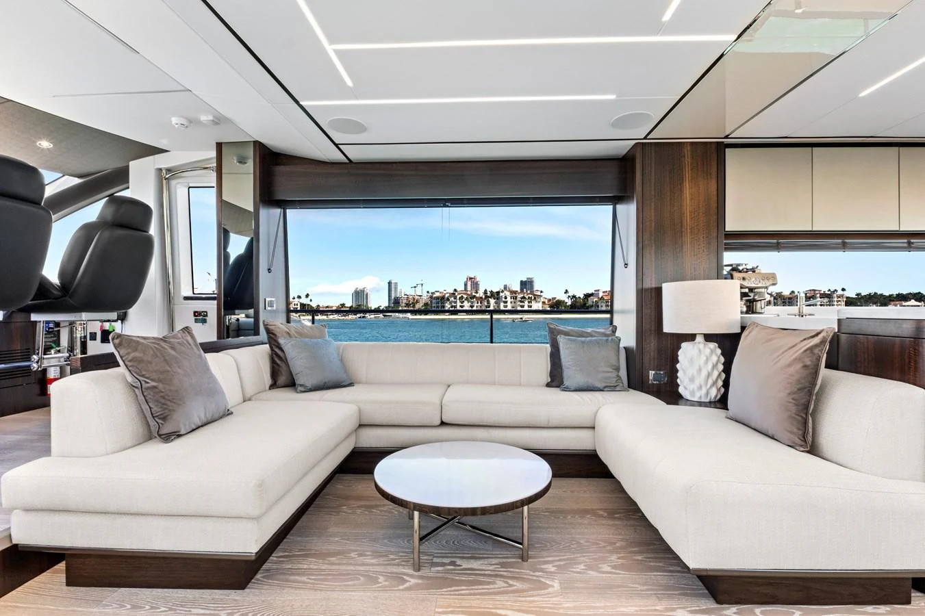 The salon features elegant seating with a panoramic view of the water and cityscape. aboard MISTY K Yacht for Sale