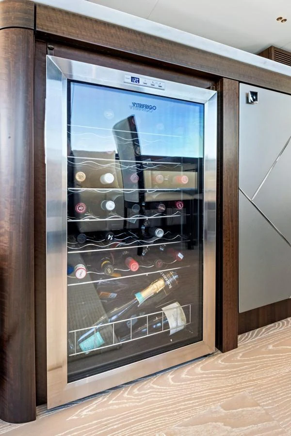 A sleek wine cooler is integrated into the yacht's interior, showcasing a selection of fine wines. aboard MISTY K Yacht for Sale