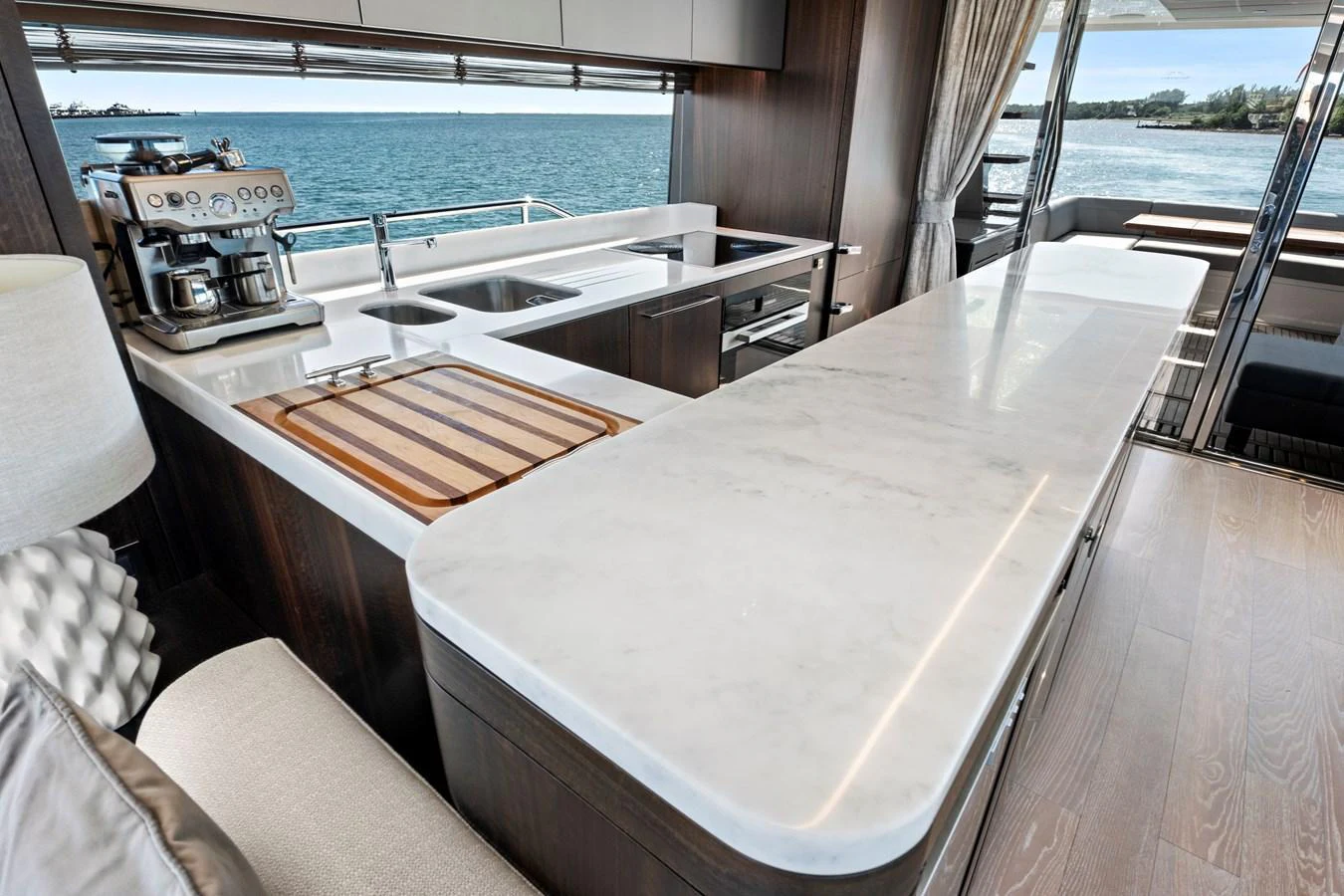 The yacht's galley features a sleek marble countertop and modern appliances with a view of the sea. aboard MISTY K Yacht for Sale
