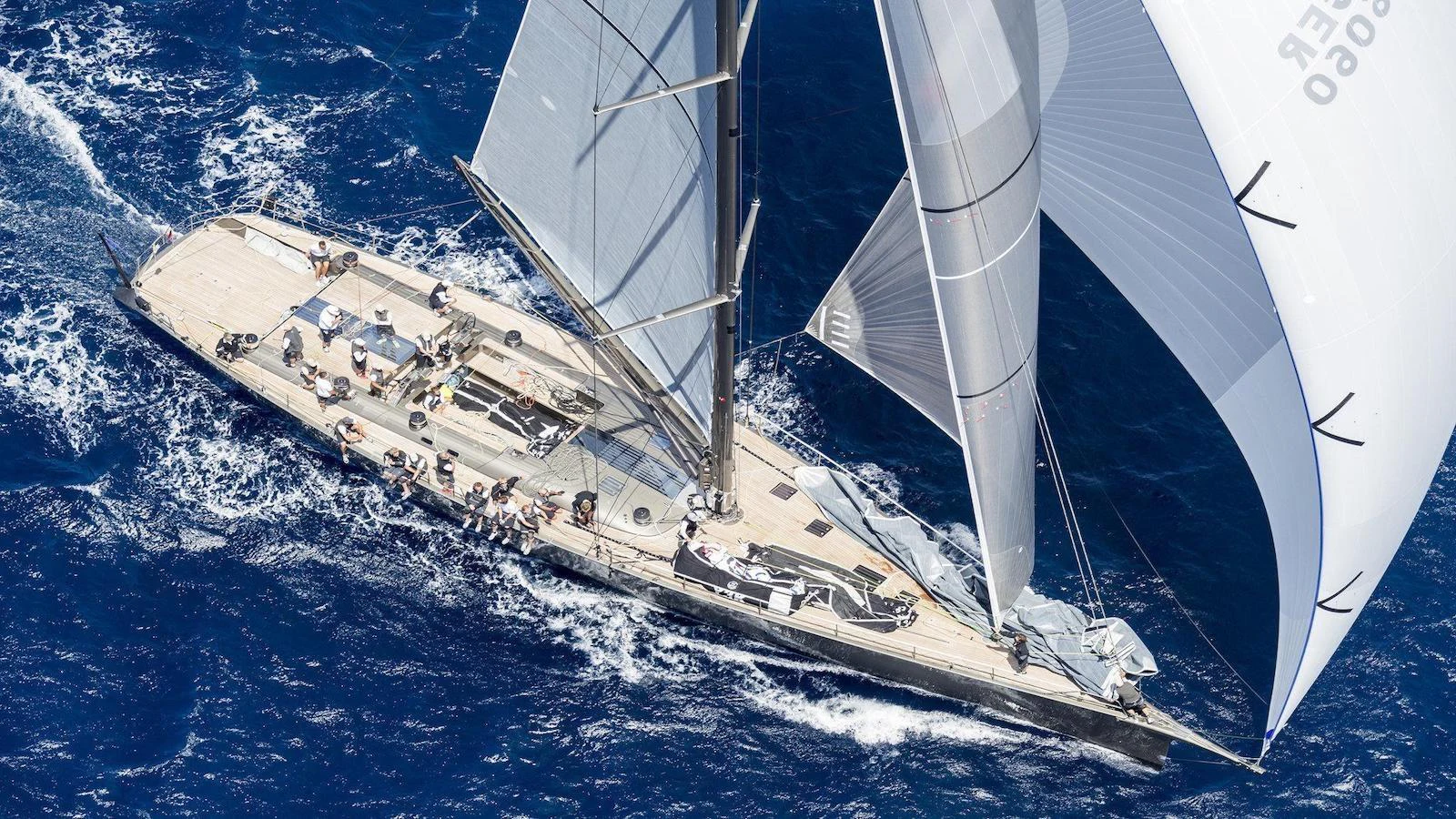 A sleek sailing yacht glides through the deep blue sea with its sails fully extended. aboard AUGUSTA WALLY Yacht for Sale