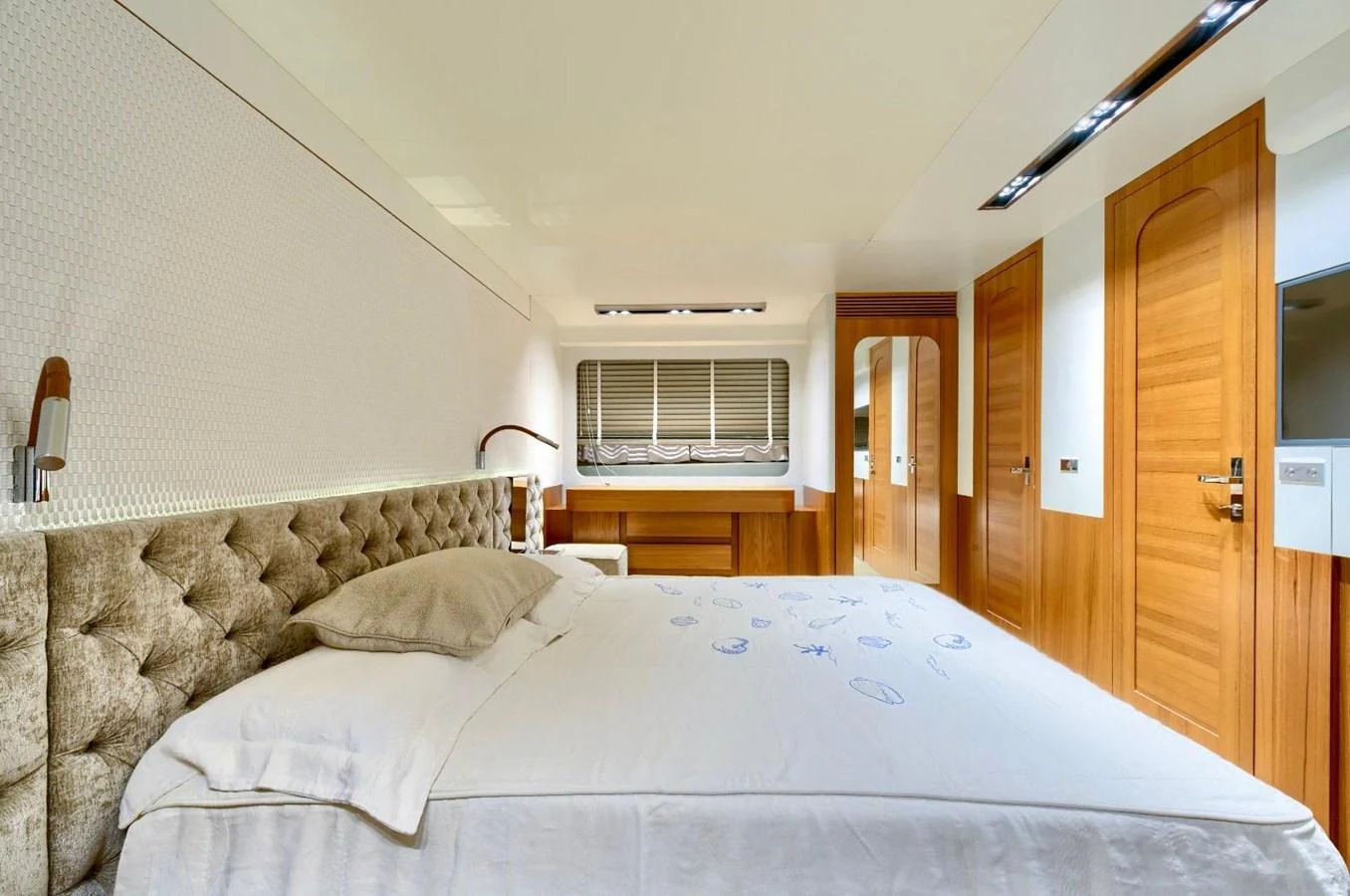 The stateroom features a plush bed with elegant wood accents and ample natural light. aboard MARIPOSA Yacht for Sale