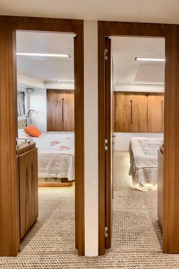 The image showcases two cozy staterooms with wooden accents and soft lighting. aboard MARIPOSA Yacht for Sale