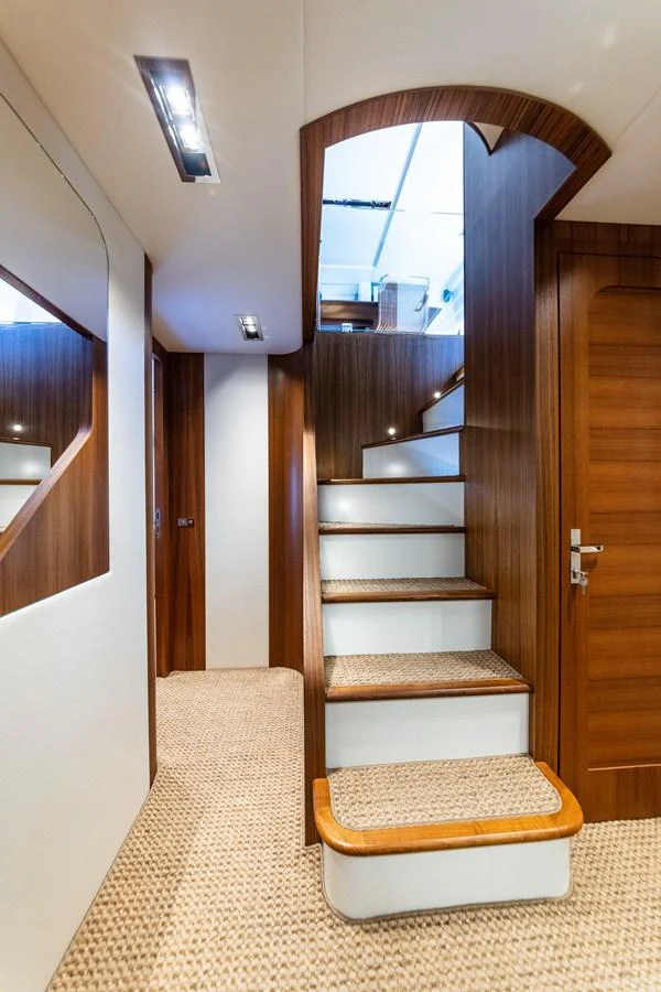 A beautifully designed interior staircase with wooden accents and plush carpeting. aboard MARIPOSA Yacht for Sale