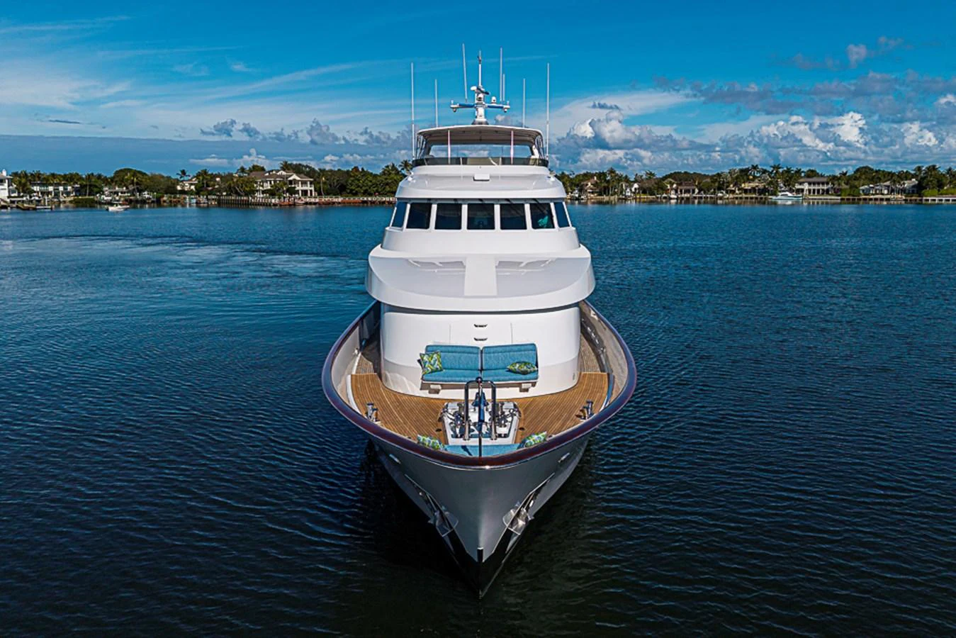 A stunning yacht is showcased head-on against a serene waterfront backdrop. aboard PROBABILITY Yacht for Sale
