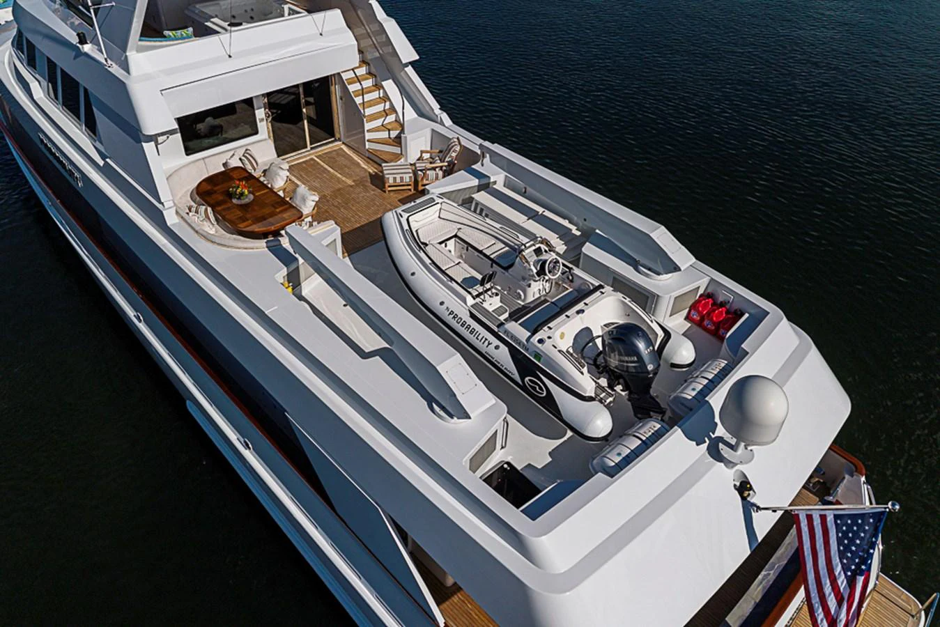 The yacht's aft deck features a tender and a spacious lounging area, perfect for relaxation and water activities. aboard PROBABILITY Yacht for Sale