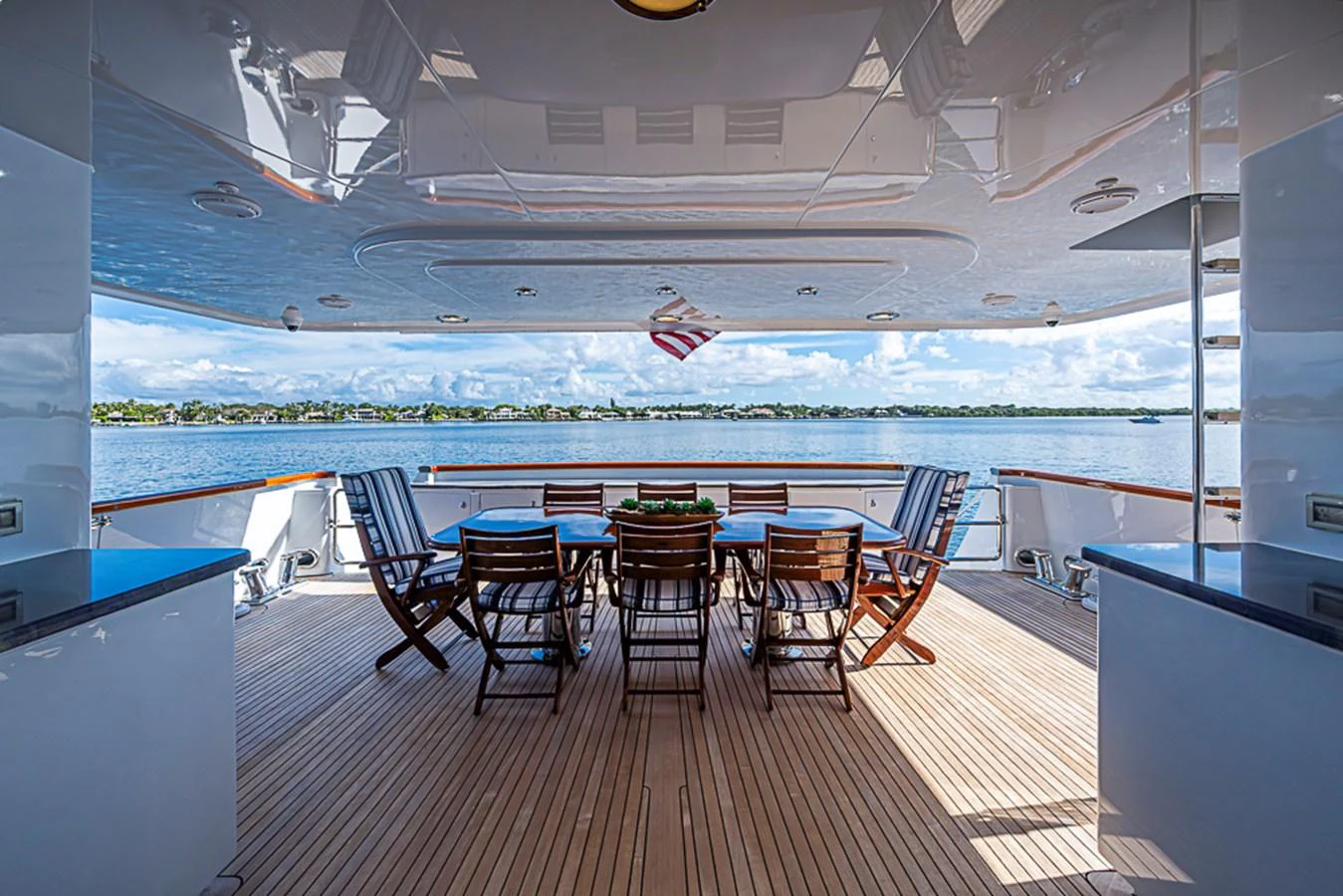 The aft deck features a spacious outdoor dining area with stunning views of the water. aboard PROBABILITY Yacht for Sale