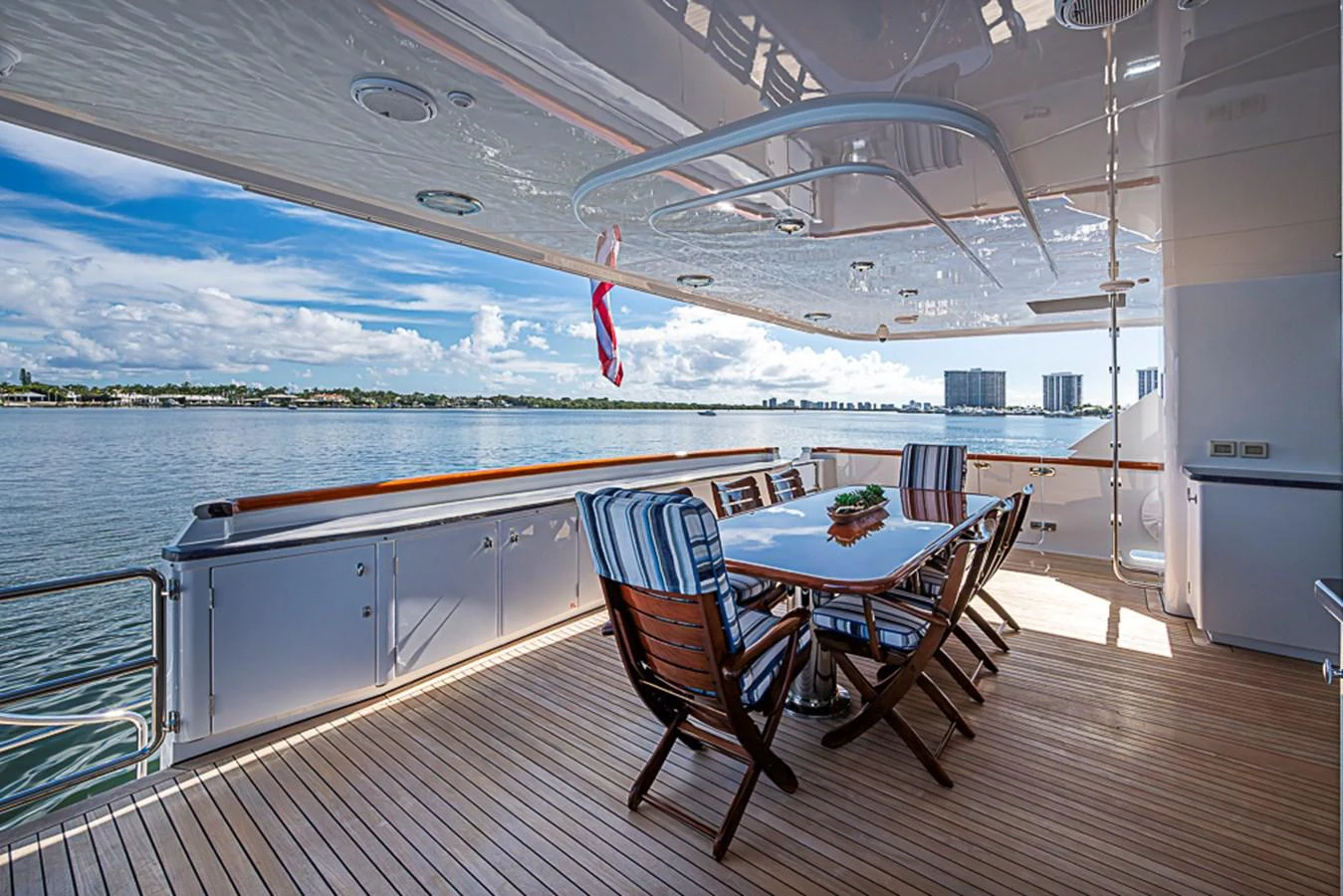 The aft deck features a stylish dining area with a stunning view of the water. aboard PROBABILITY Yacht for Sale