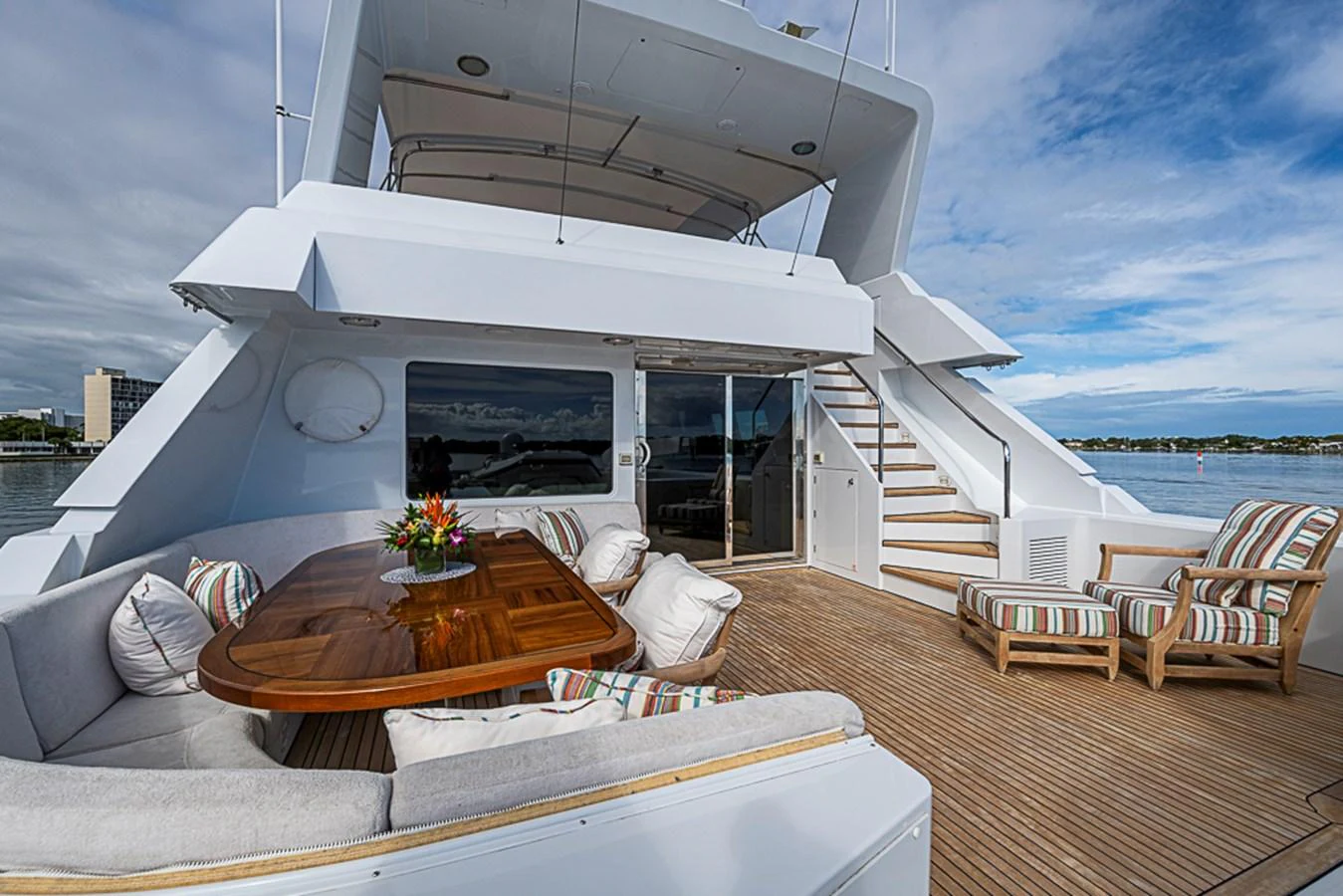 The aft deck features a spacious seating area with a wooden table and comfortable cushions, perfect for outdoor relaxation. aboard PROBABILITY Yacht for Sale