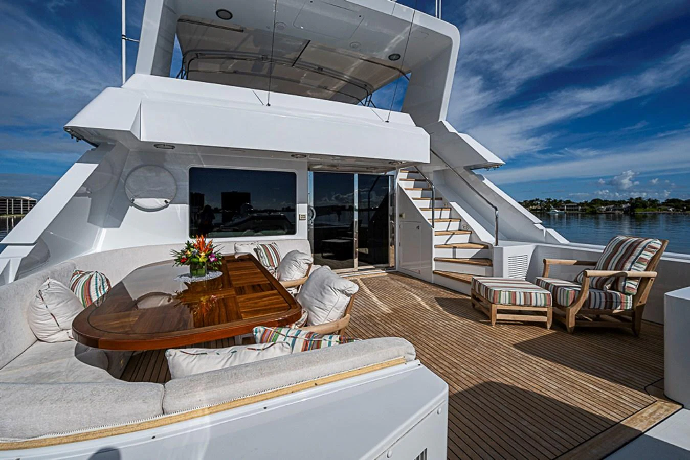 The aft deck offers a spacious and inviting area for relaxation and socializing with comfortable seating and a beautiful wooden table. aboard PROBABILITY Yacht for Sale
