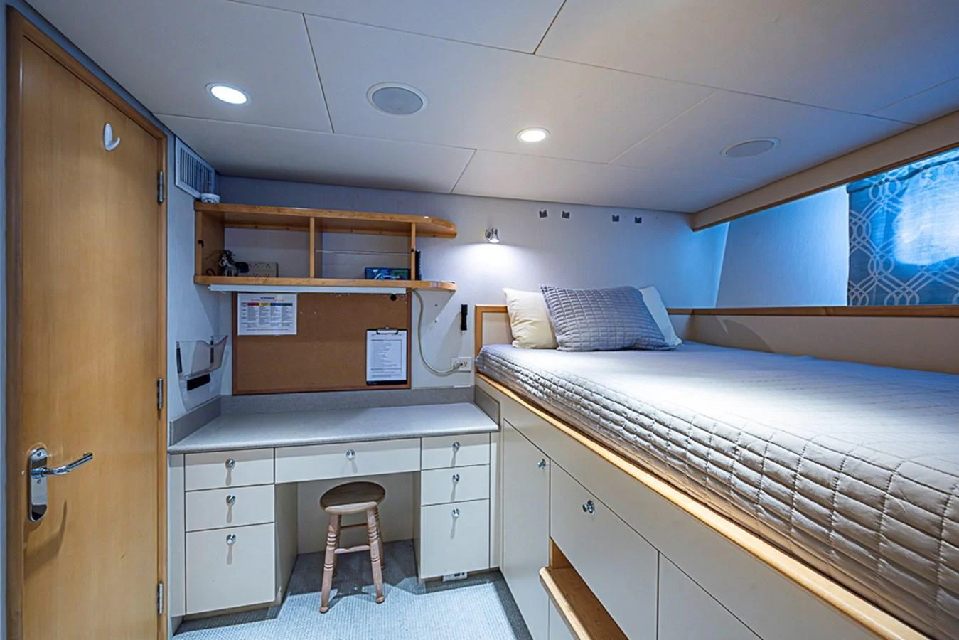A cozy cabin with a raised bed, desk, and ample storage space. aboard PROBABILITY Yacht for Sale