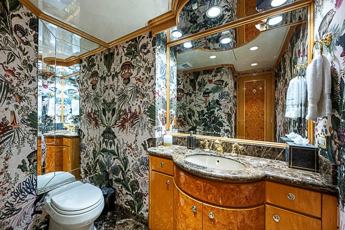 The yacht's bathroom features luxurious marble countertops and vibrant floral wallpaper. aboard PROBABILITY Yacht for Sale