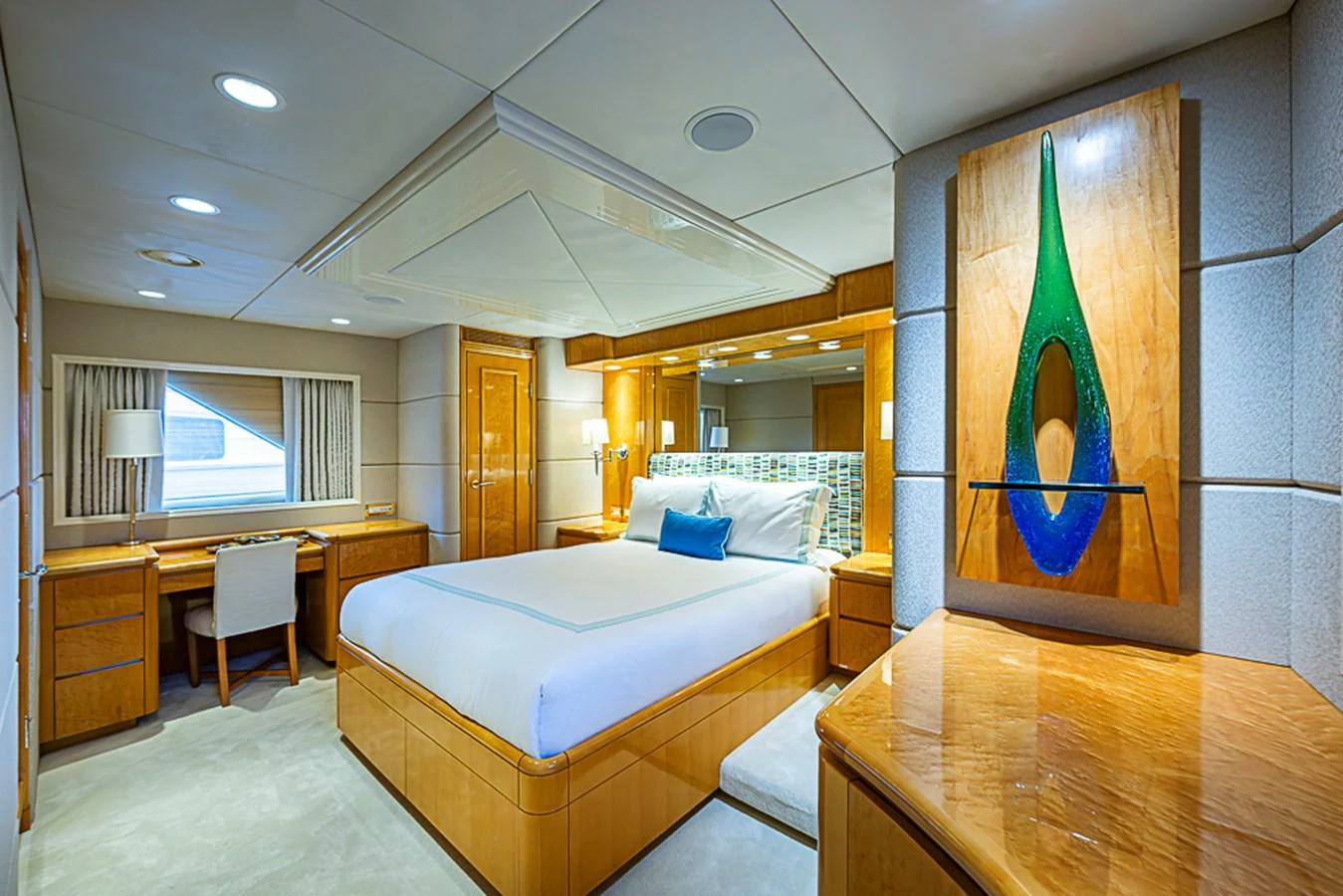 This luxurious stateroom features a comfortable bed, elegant wood furnishings, and modern decor. aboard PROBABILITY Yacht for Sale
