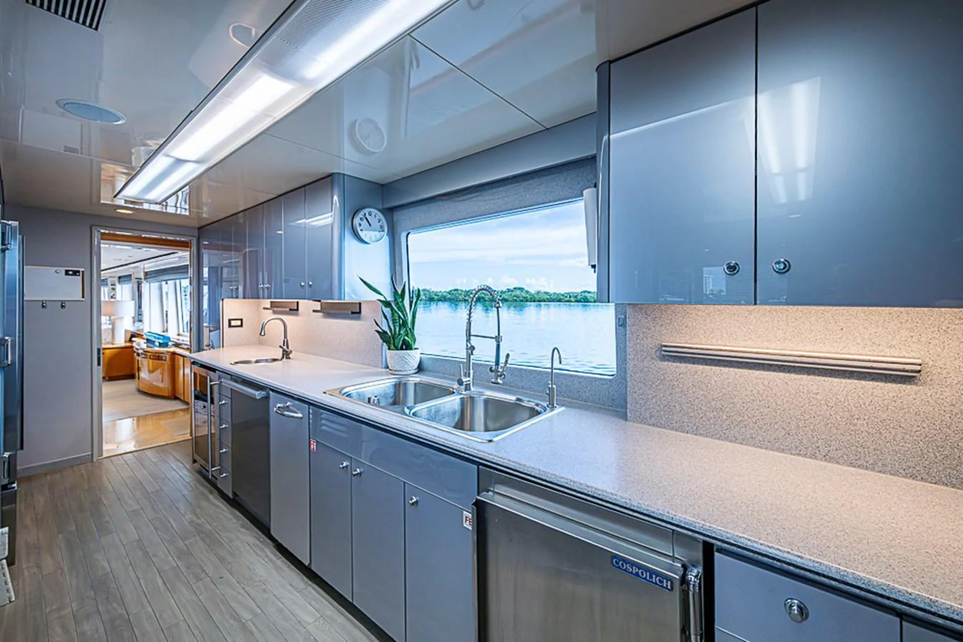 The modern galley features sleek cabinetry, ample counter space, and large windows with a view of the water. aboard PROBABILITY Yacht for Sale