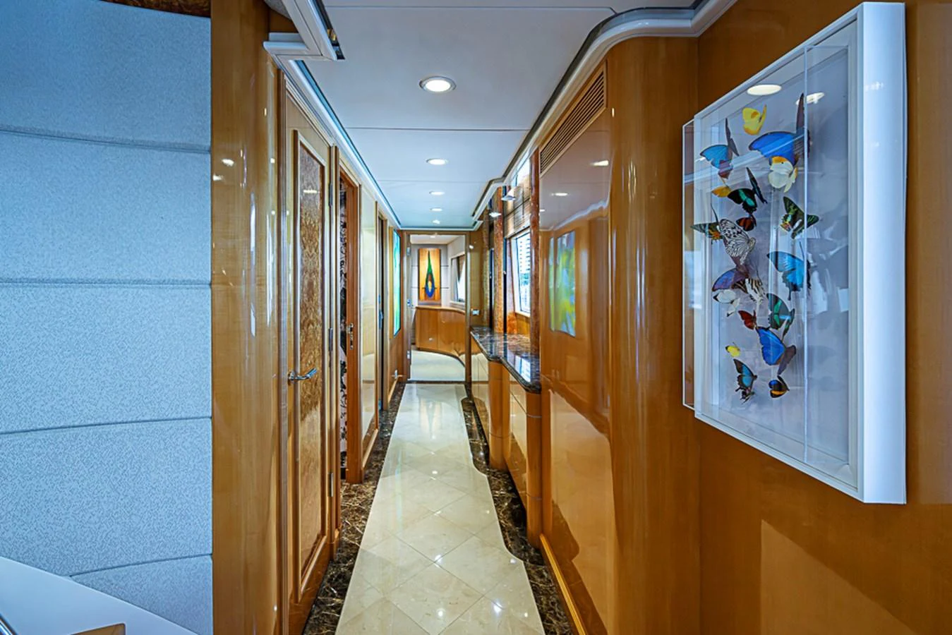 A luxurious hallway with elegant wood paneling and modern artwork. aboard PROBABILITY Yacht for Sale