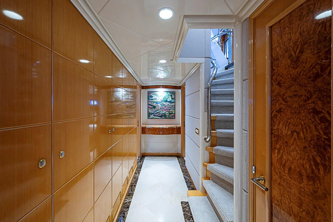 A luxurious hallway with polished wood paneling and a staircase leading to the upper deck. aboard PROBABILITY Yacht for Sale