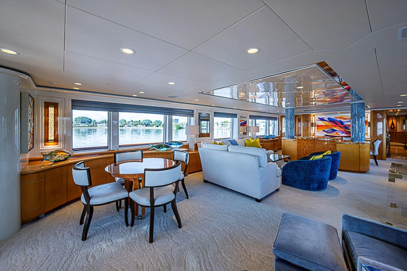 The yacht's salon features elegant seating, a dining area, and large windows offering panoramic views. aboard PROBABILITY Yacht for Sale