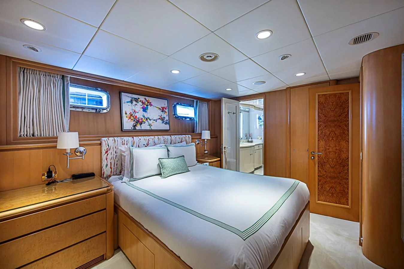 A luxurious stateroom featuring a comfortable bed and elegant wooden furnishings. aboard PROBABILITY Yacht for Sale