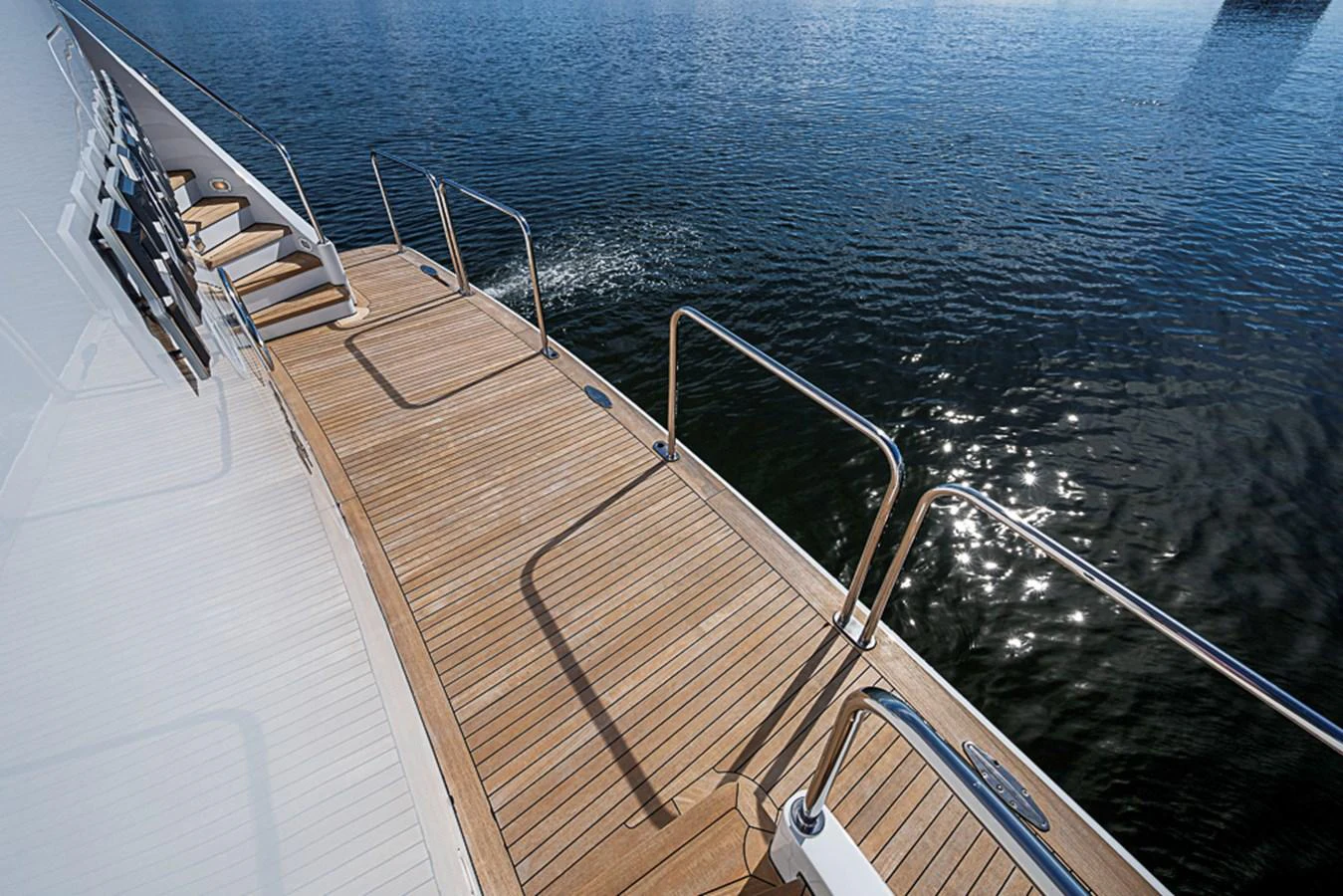 The yacht's side deck features elegant teak flooring and sleek stainless steel railings, offering a safe and stylish passage. aboard PROBABILITY Yacht for Sale