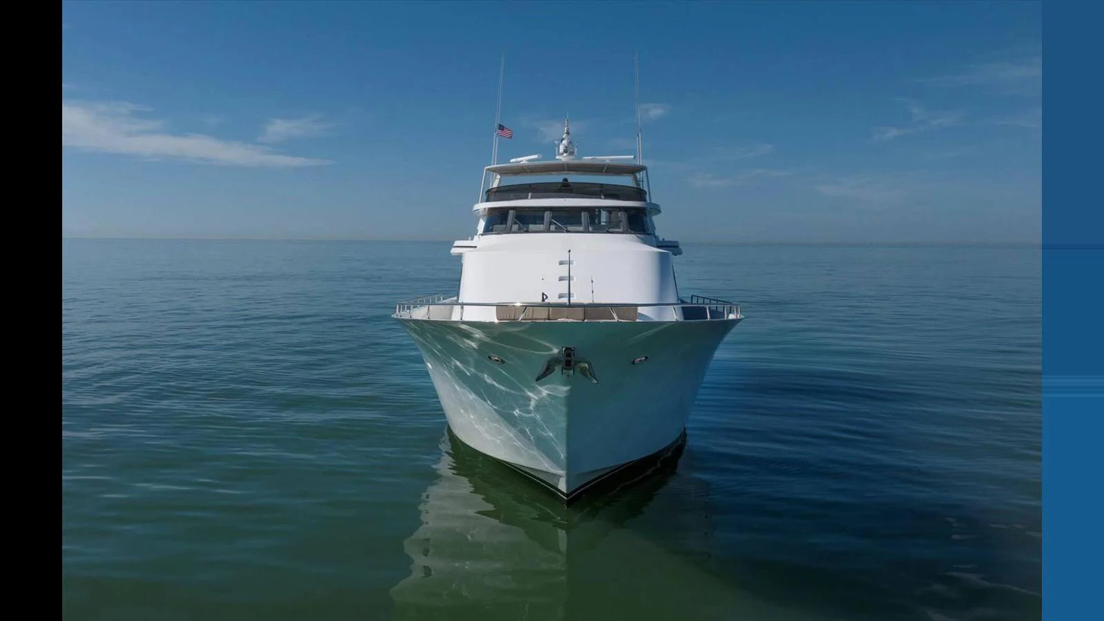 A stunning yacht is captured head-on, showcasing its sleek design against a calm sea. aboard THINK B.I.G Yacht for Sale