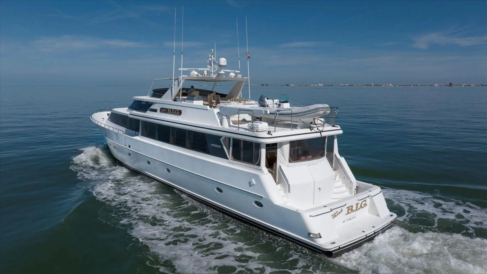 A sleek and spacious yacht cruises smoothly on calm waters under a clear sky. aboard THINK B.I.G Yacht for Sale