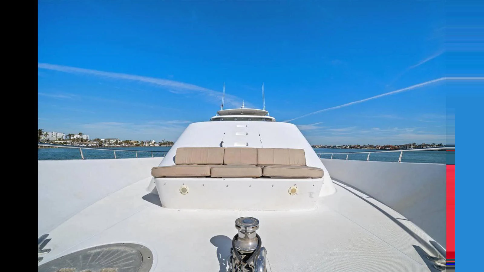 The yacht's bow area features a spacious sunpad under a clear blue sky. aboard THINK B.I.G Yacht for Sale