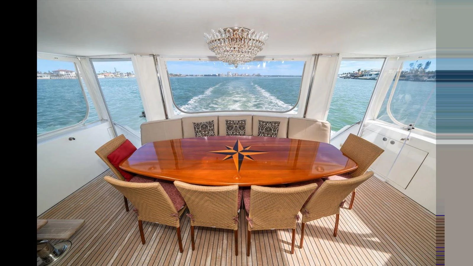 The yacht's dining area offers a stunning view of the water, featuring a polished wooden table and comfortable seating. aboard THINK B.I.G Yacht for Sale