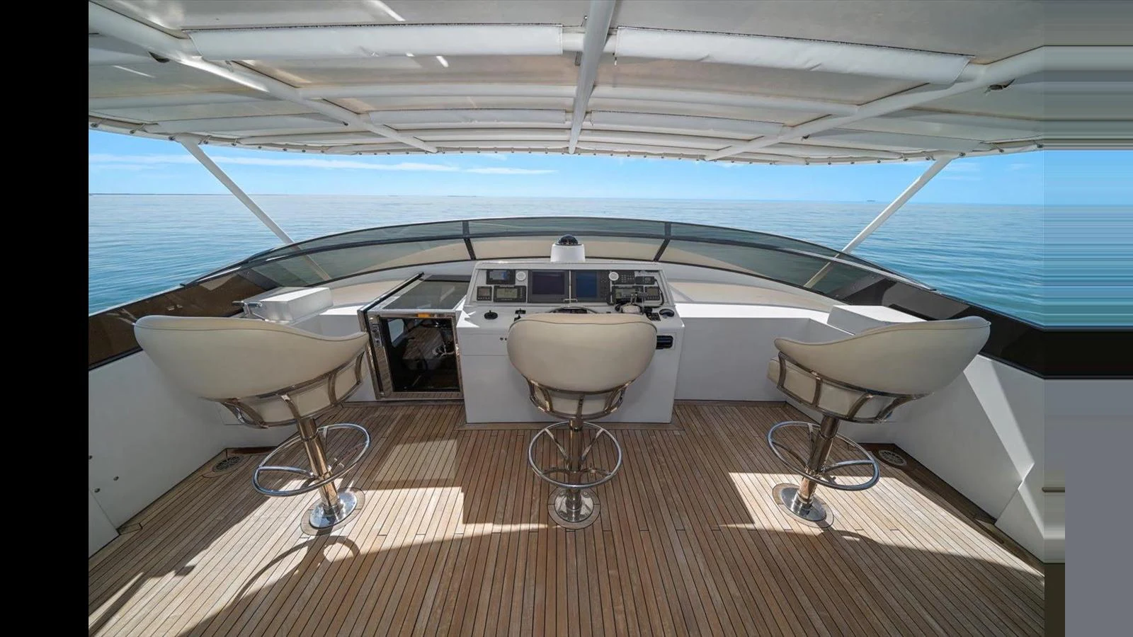 The helm station features modern controls and comfortable seating with a panoramic view of the sea. aboard THINK B.I.G Yacht for Sale