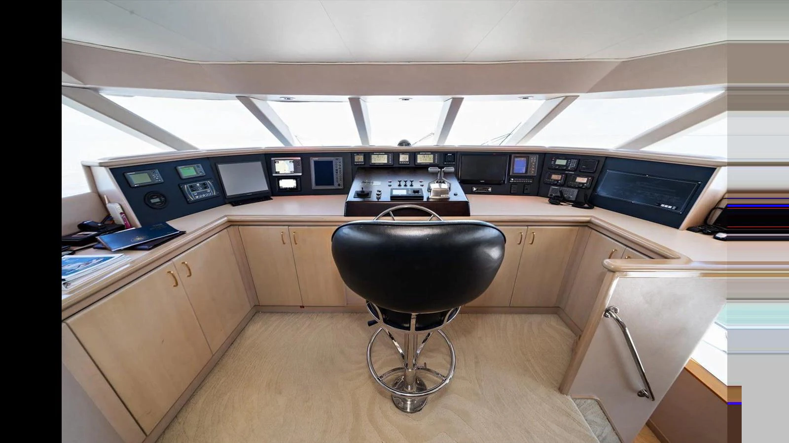 The helm station features a sleek design with modern navigation equipment and a comfortable captain's chair. aboard THINK B.I.G Yacht for Sale