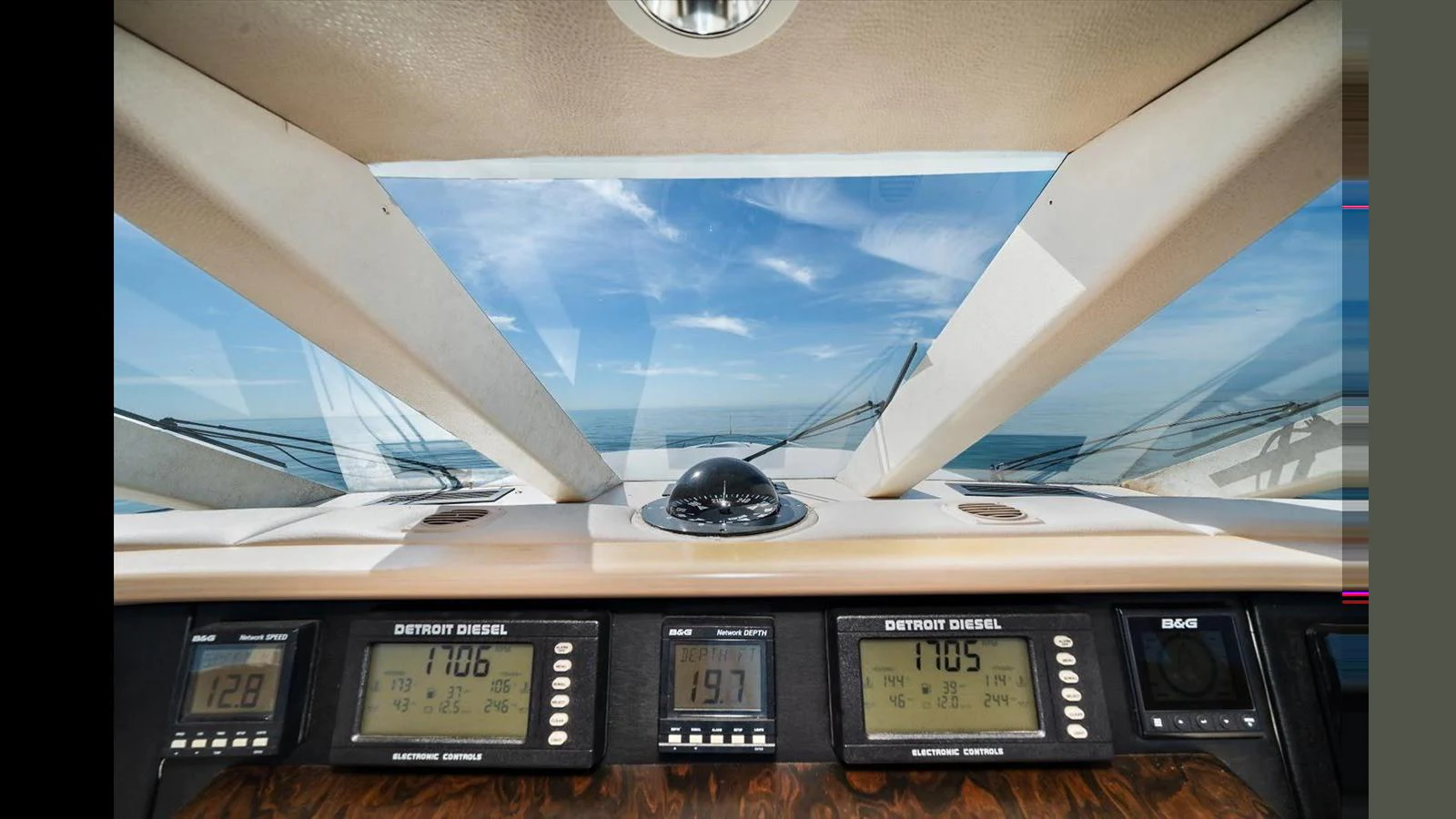 The helm station features advanced navigation instruments and a panoramic view through the windshield. aboard THINK B.I.G Yacht for Sale