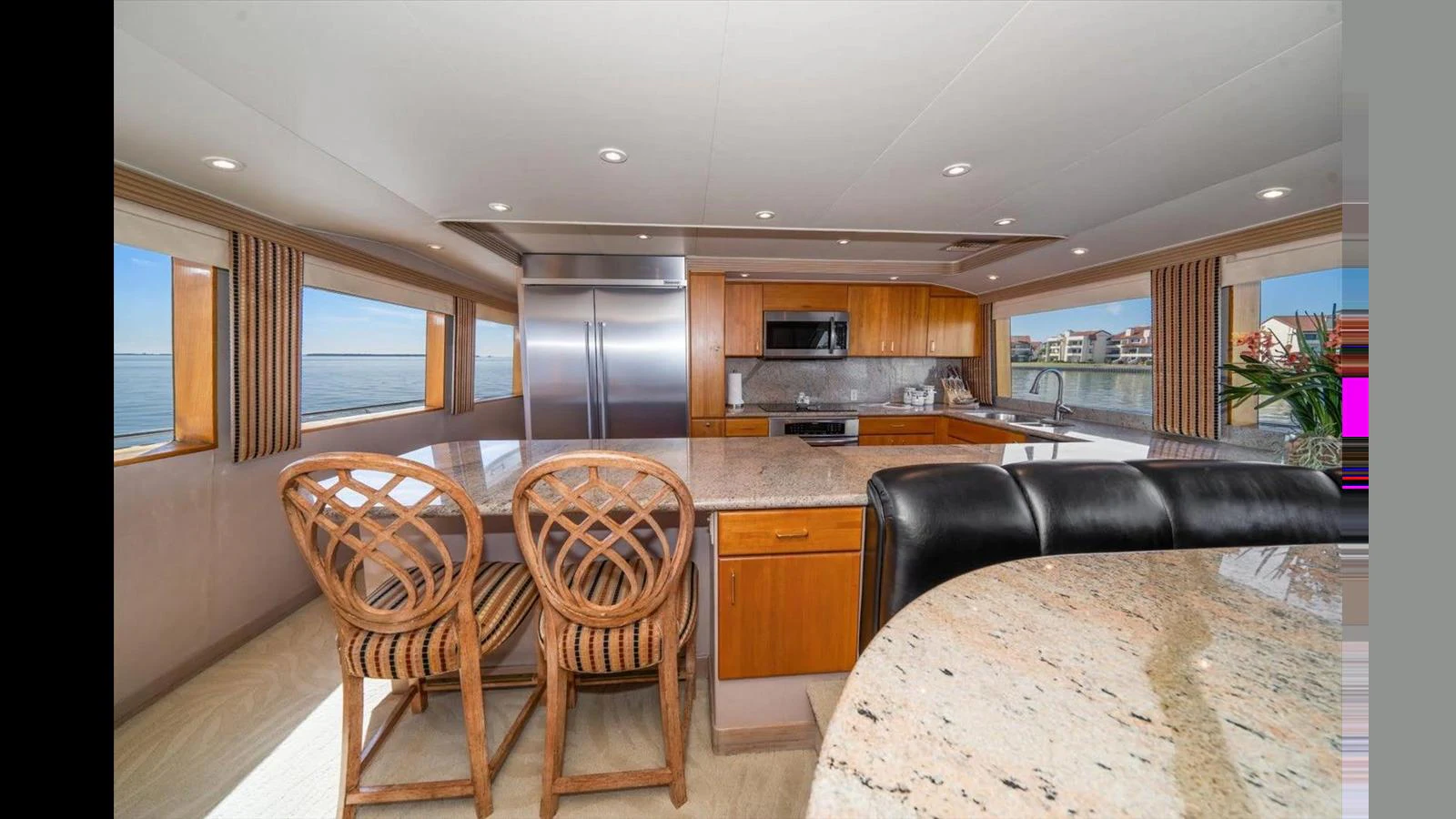 The yacht's galley features modern appliances, a large countertop, and ample seating with panoramic views. aboard THINK B.I.G Yacht for Sale