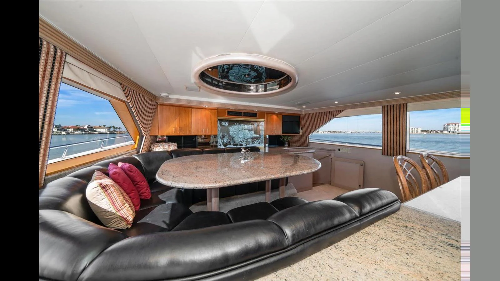 The salon features a luxurious seating area with a large dining table and panoramic windows offering stunning views. aboard THINK B.I.G Yacht for Sale