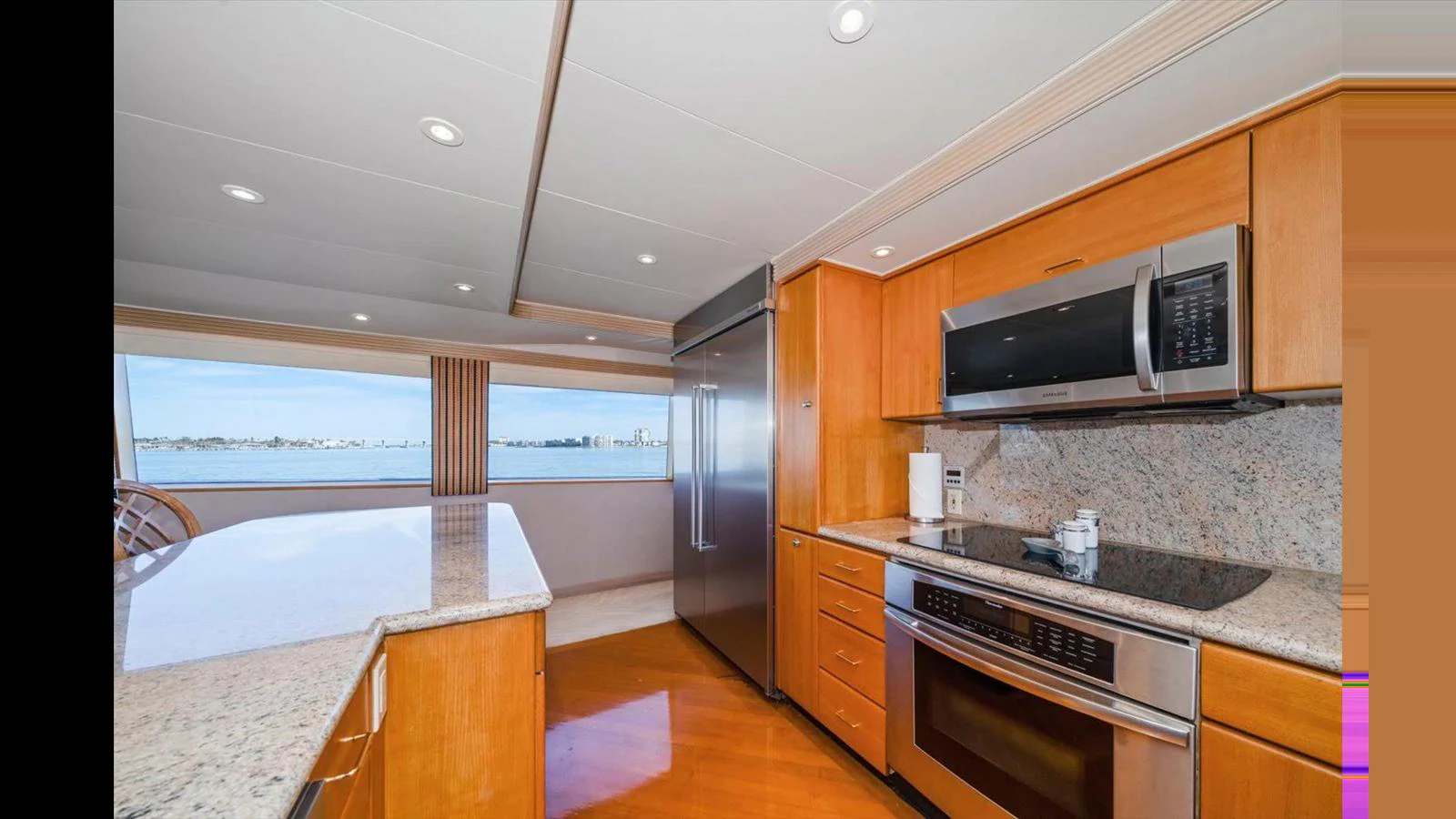 The galley features modern appliances and ample counter space with a view of the sea. aboard THINK B.I.G Yacht for Sale