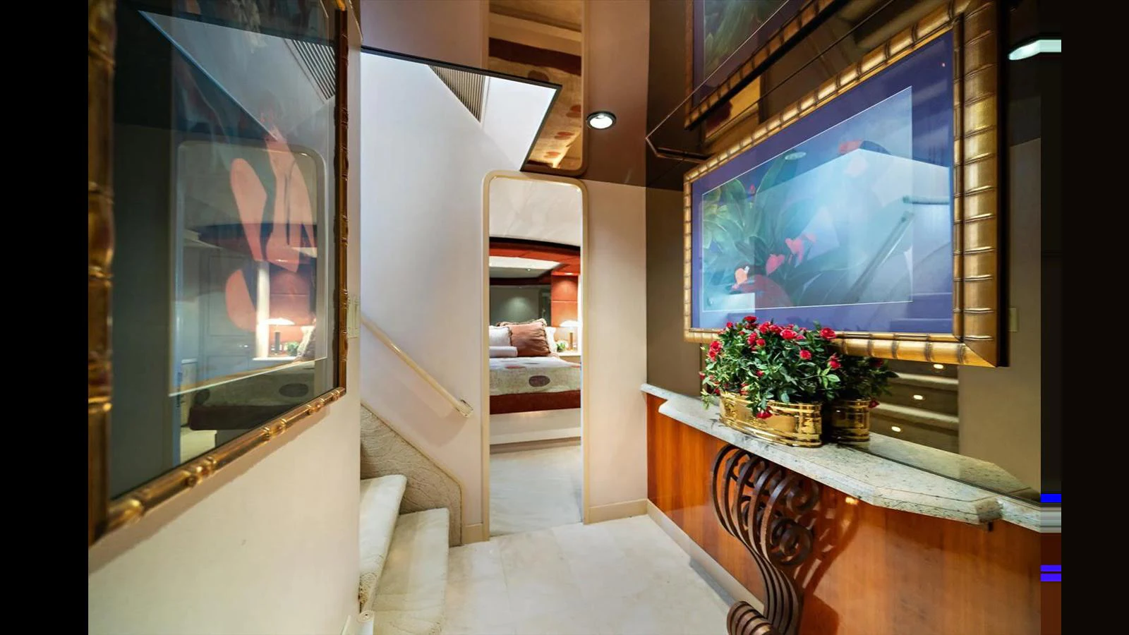A luxurious hallway leading to a cozy stateroom, adorned with elegant decor and vibrant flowers. aboard THINK B.I.G Yacht for Sale