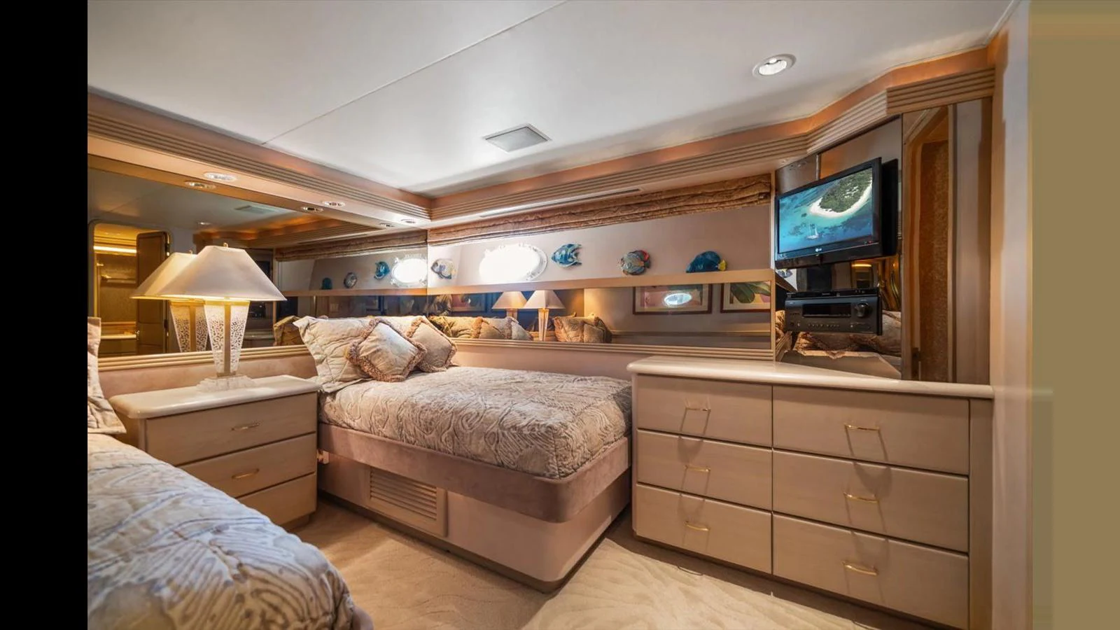 The stateroom features a cozy bed, elegant decor, and a mounted television for ultimate relaxation. aboard THINK B.I.G Yacht for Sale