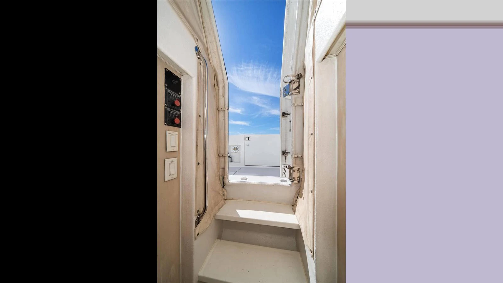 A stairway leads up to an open deck area under a clear blue sky. aboard THINK B.I.G Yacht for Sale