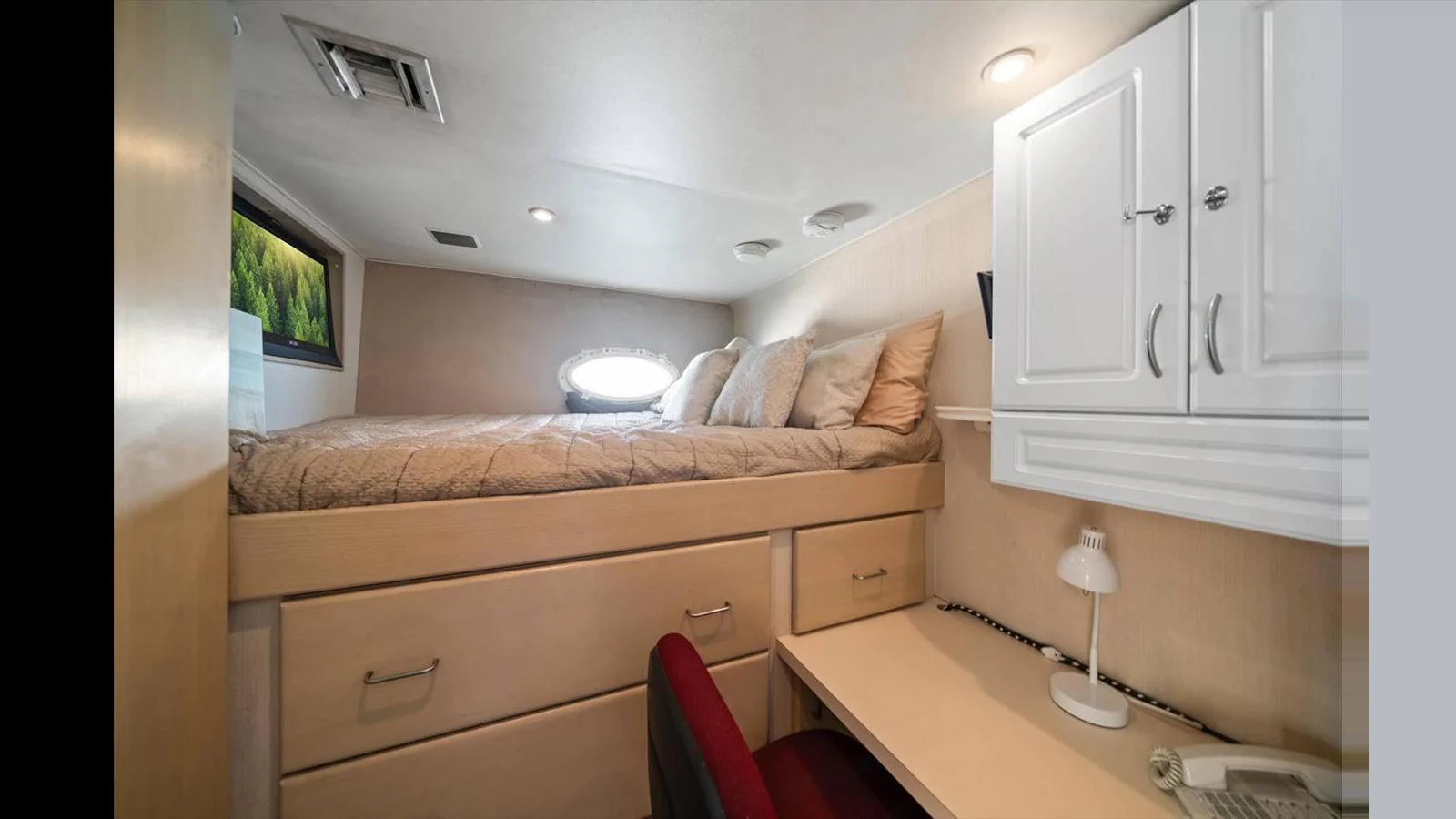 A cozy cabin with a comfortable bed and a small desk area, perfect for relaxation and work. aboard THINK B.I.G Yacht for Sale