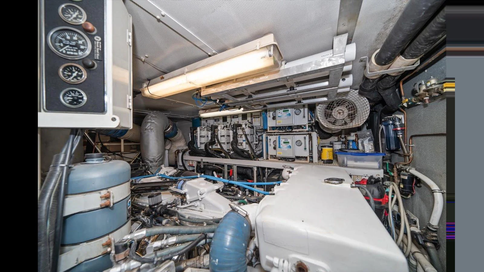 The image showcases the yacht's well-maintained engine room with various mechanical components and gauges. aboard THINK B.I.G Yacht for Sale