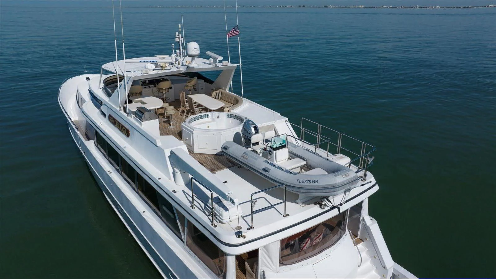 The yacht's sundeck features a spacious layout with a hot tub and ample seating, perfect for relaxation and entertainment. aboard THINK B.I.G Yacht for Sale
