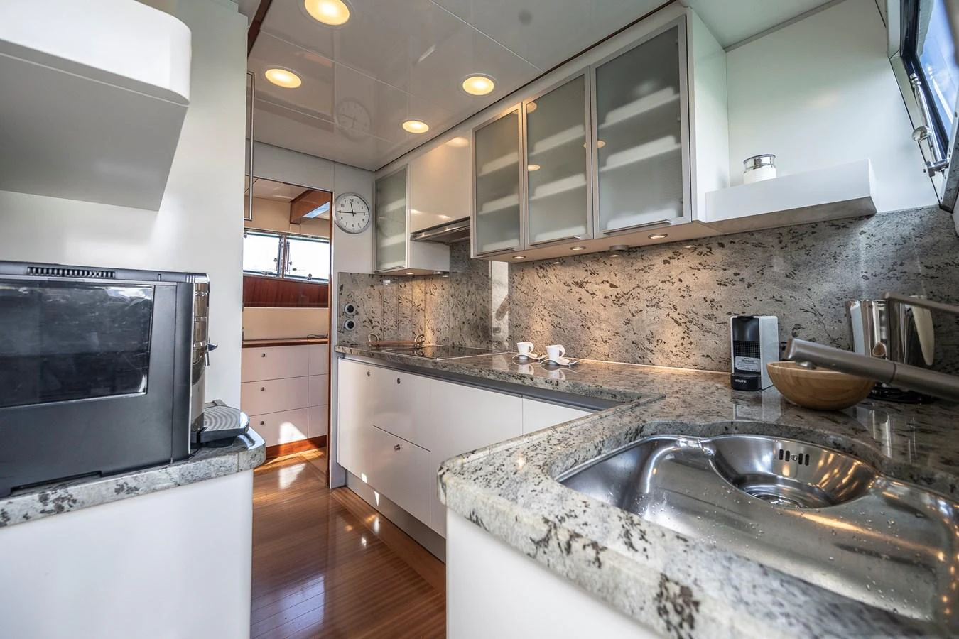 a kitchen with white cabinets aboard AXEBT Yacht for Sale