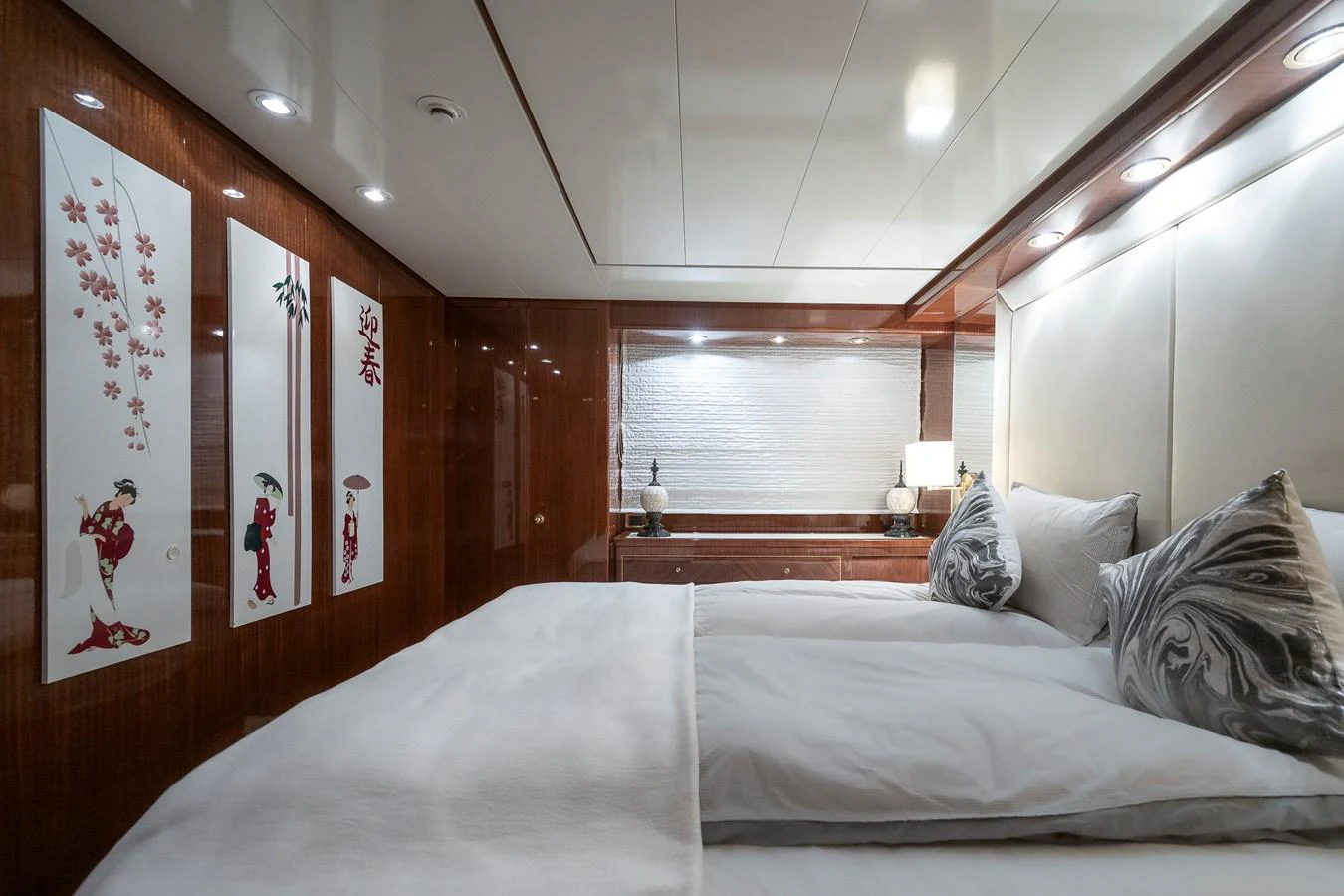 a bed with a white sheet and a red wall aboard AXEBT Yacht for Sale