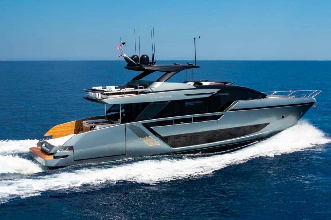 A sleek and modern yacht cruising on the open sea under a clear blue sky. aboard COCO Y Yacht for Sale