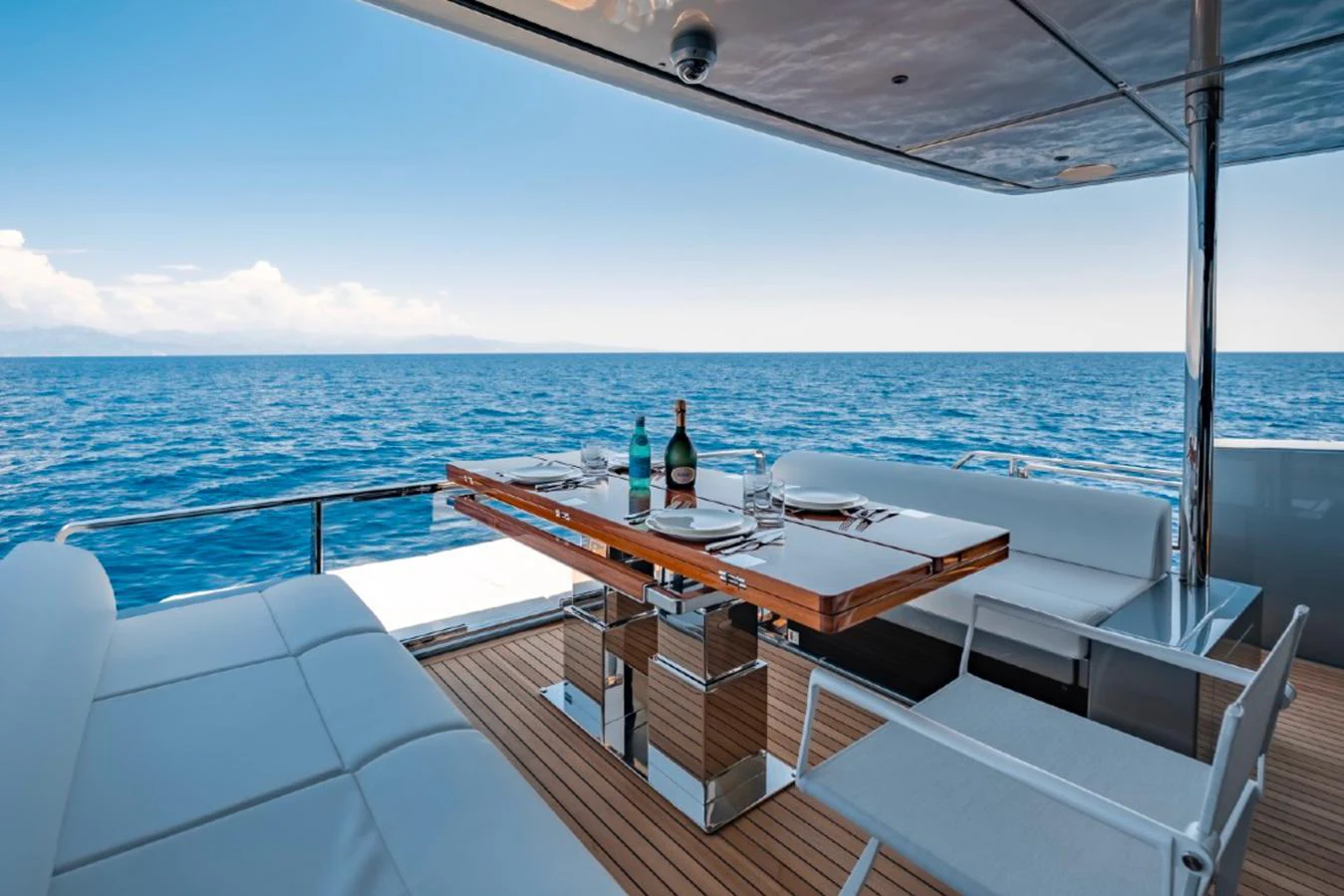 The aft deck offers a luxurious dining area with stunning ocean views. aboard COCO Y Yacht for Sale