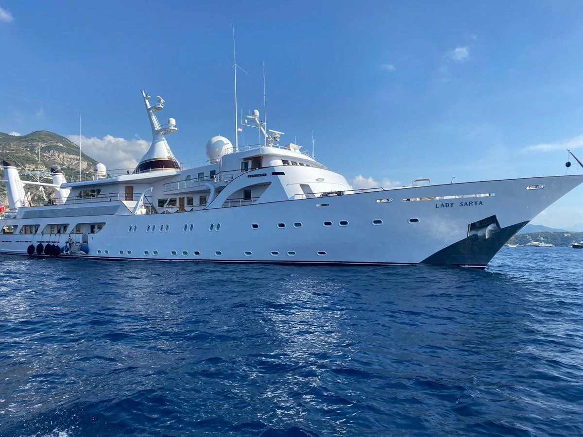 A luxurious yacht is anchored on a serene blue sea under a clear sky. aboard LADY SARYA Yacht for Sale