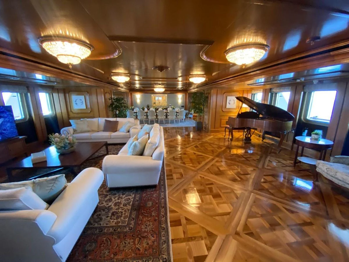 The yacht's salon features luxurious seating, a grand piano, and elegant lighting, creating a sophisticated ambiance. aboard LADY SARYA Yacht for Sale