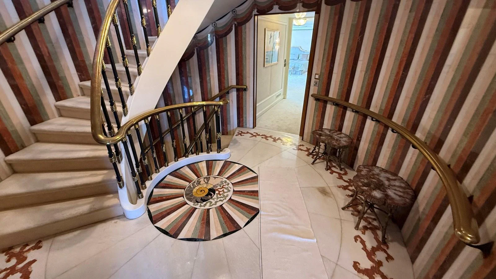 A luxurious interior staircase with elegant railings and a decorative floor design. aboard LADY SARYA Yacht for Sale
