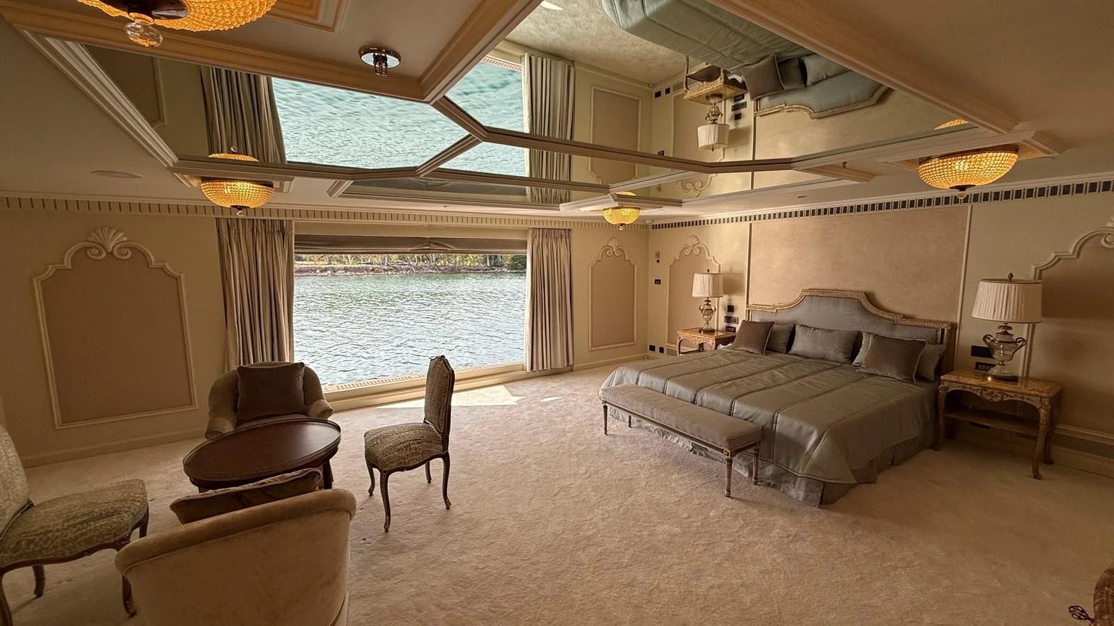 The master stateroom features elegant furnishings and a large window with a view of the water. aboard LADY SARYA Yacht for Sale