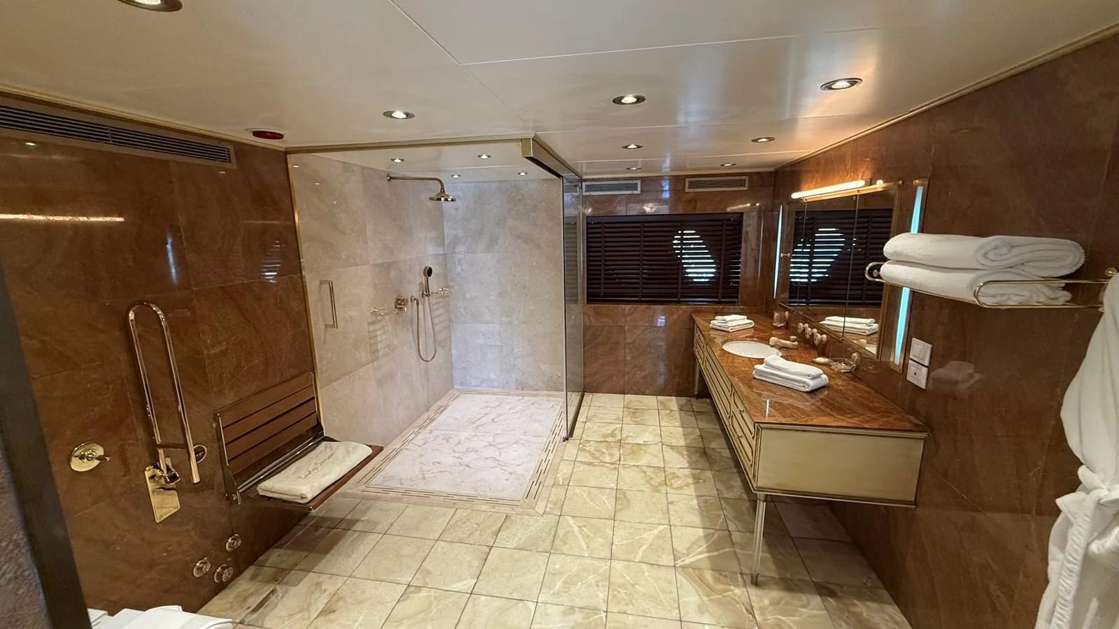 The yacht's bathroom features luxurious marble finishes and a spacious walk-in shower. aboard LADY SARYA Yacht for Sale